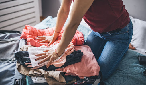 Person folding clothes on be.